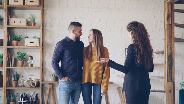 Young couple discussing real estate options with an agent in a stylish loft apartment.