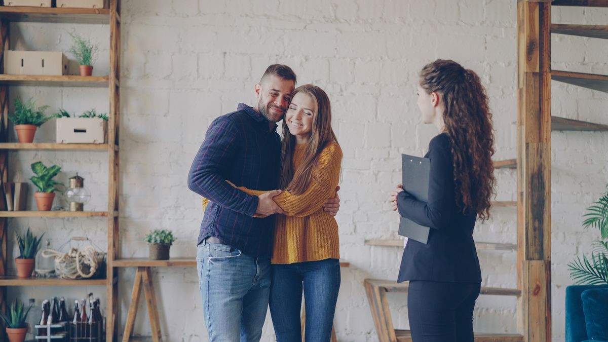 Happy couple celebrating a successful home purchase with a real estate professional