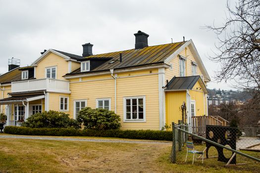 Charming yellow Scandinavian house in Huskvarna, Jonkoping County, Sweden on a cloudy day.