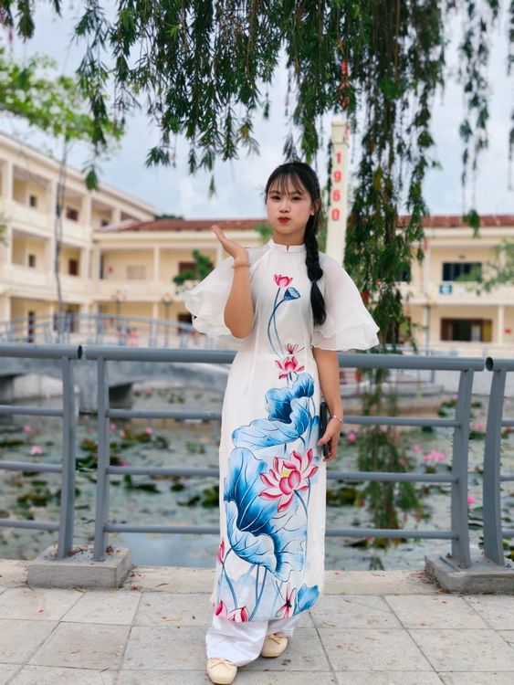 Elegant Woman in Floral Dress by a Pond · Free Stock Photo
