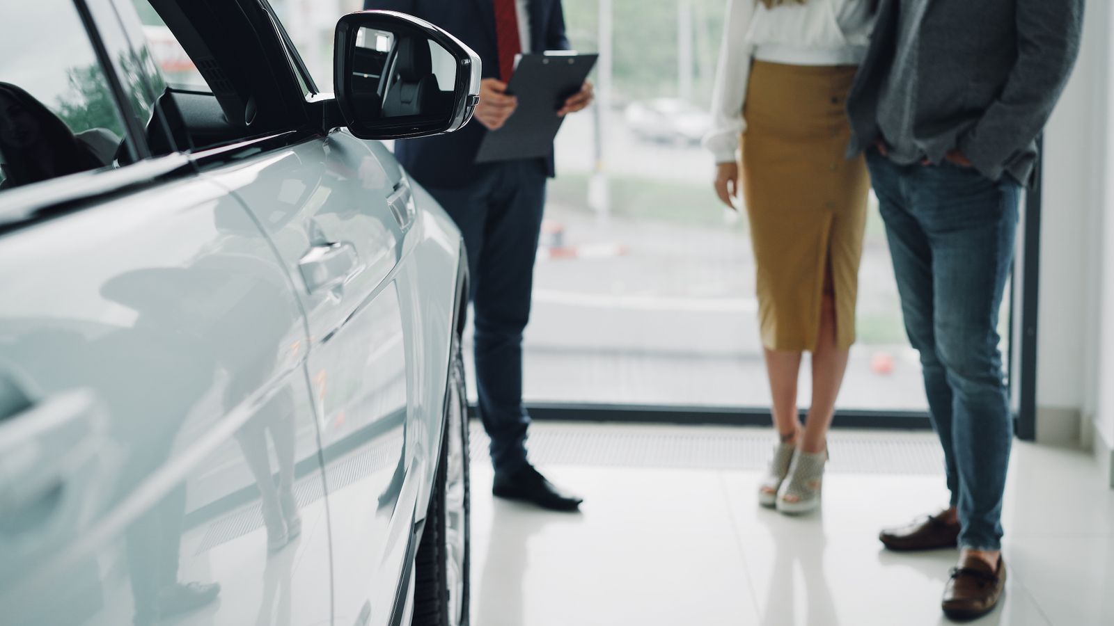 Venditore e cliente durante una consulenza in concessionaria, a colloquio su opzioni di acquisto auto