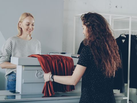 A retail assistant helping a customer at a shop counter