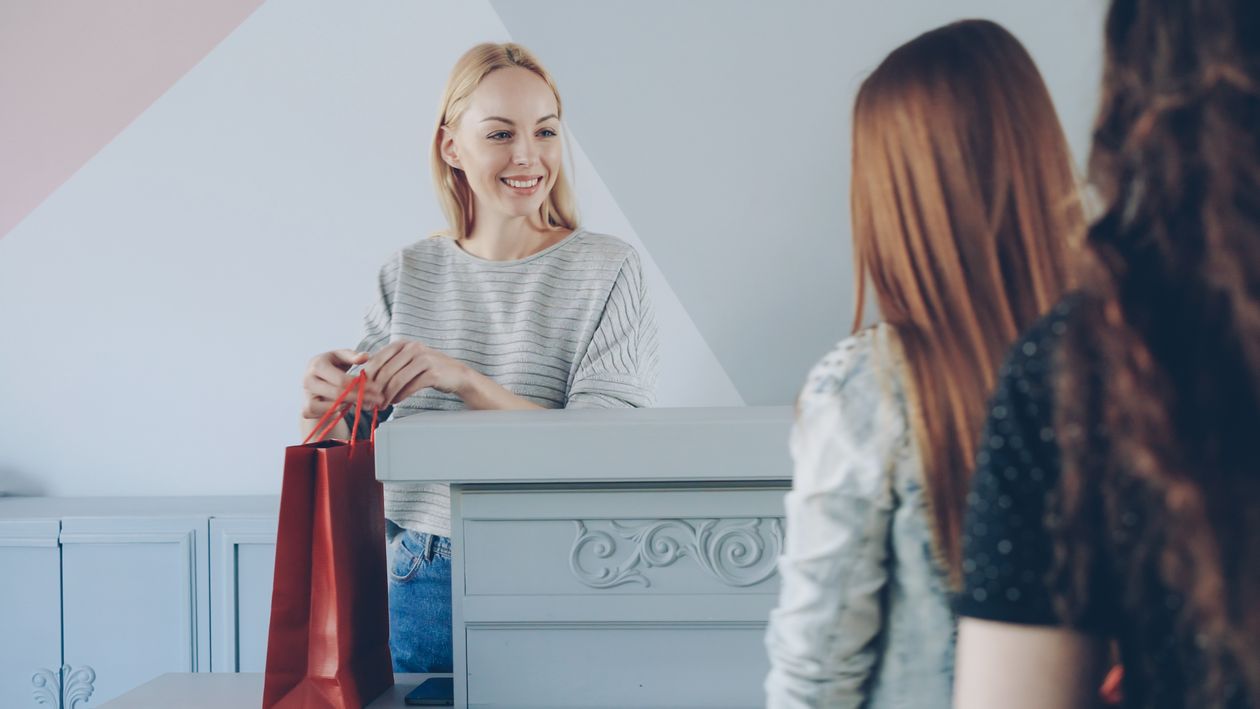cashier hands shopping bag customer