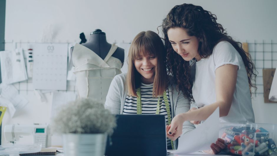 Two female designers working together creatively in their fashion studio.