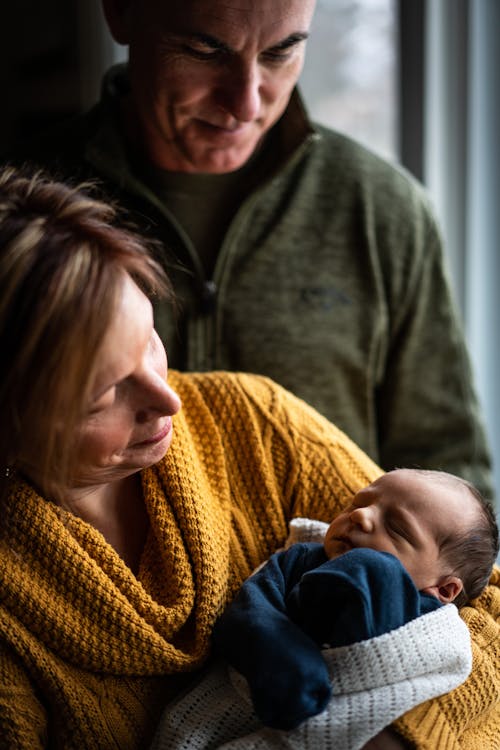 Woman in Yellow Knit Sweater Carrying Baby