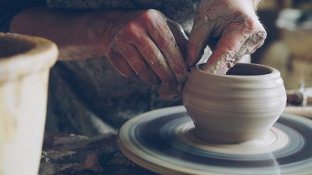 Artisan shaping clay on a spinning wheel — photo by Vitaly Gariev on Pexels