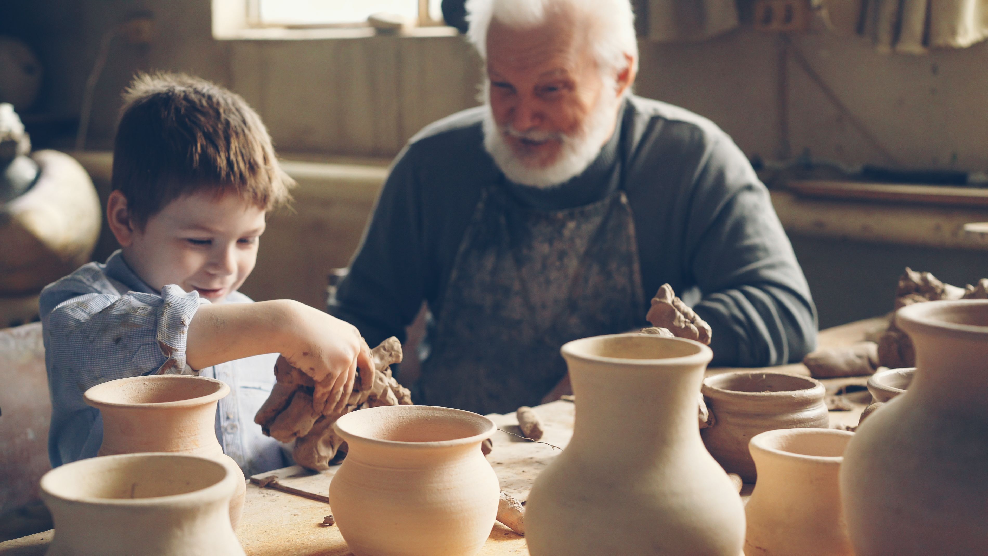 Child and Senior Enjoy Pottery Making Together · Free Stock Photo