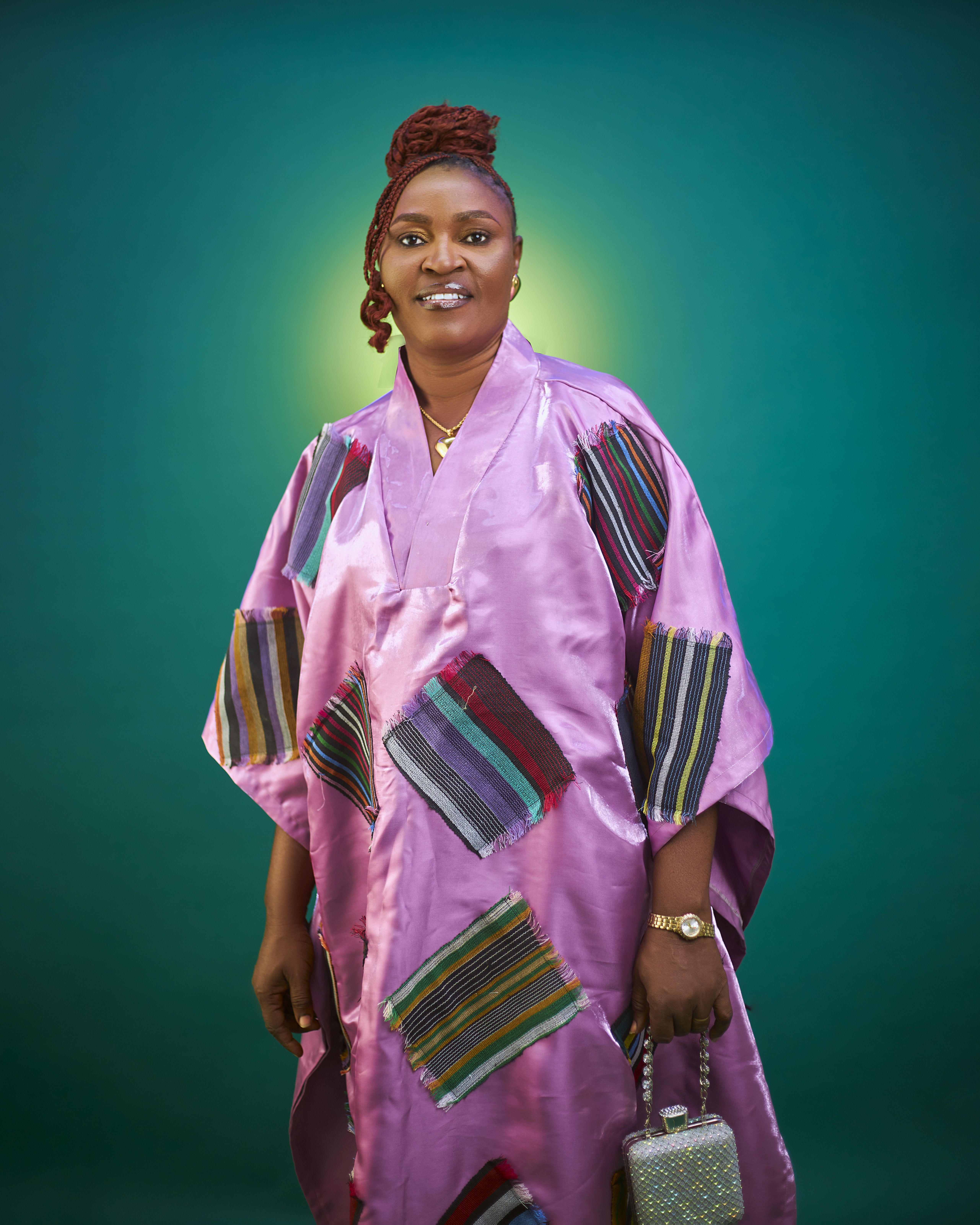 Elegant portrait of an African woman in a vibrant purple traditional dress with a green gradient background.