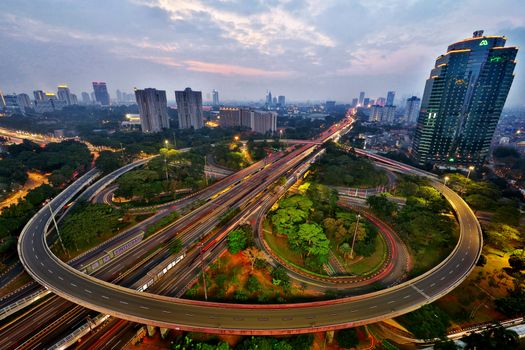 Stunning aerial view of Jakarta's busy highway interchange illuminated at dusk.