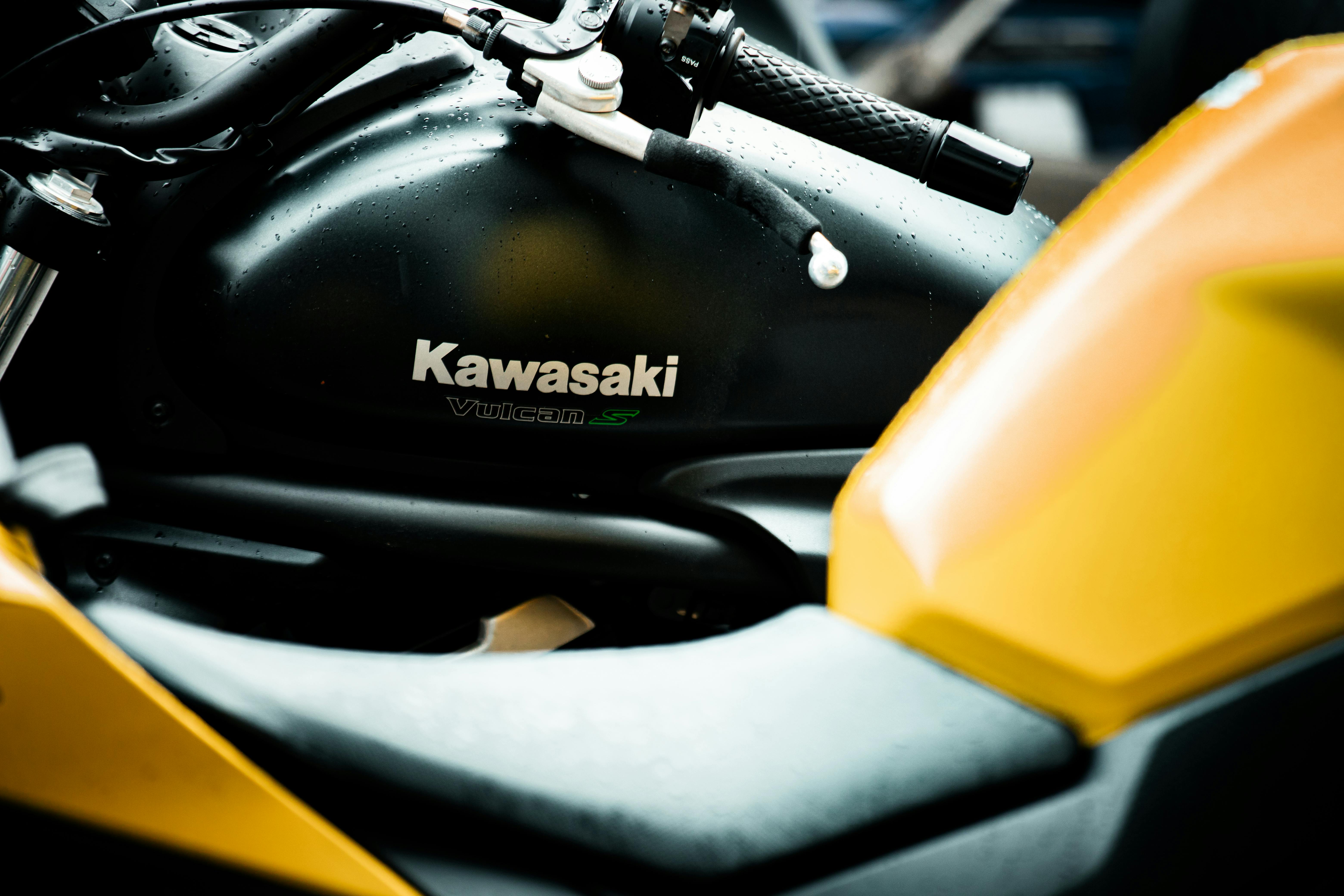 Close-up of a Kawasaki Vulcan S motorcycle's tank and handlebar with raindrops, highlighting its sleek design.