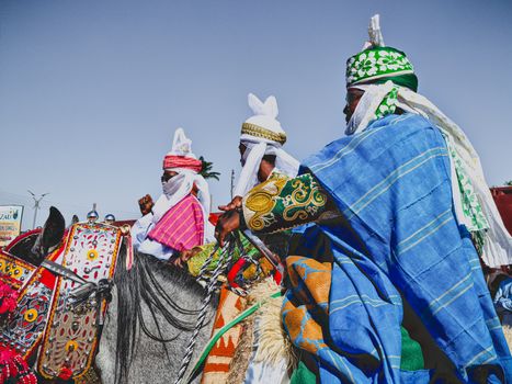 Colorful traditional equestrian festival with riders in vibrant attire in Zaria, Nigeria.