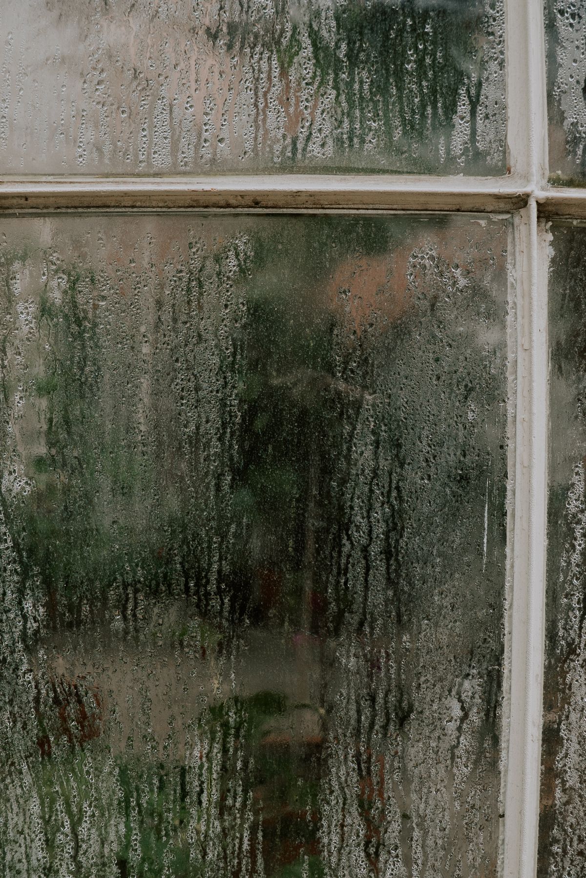 Beschlagene Fensterscheibe mit Kondenswassertropfen, winterliche Stimmung