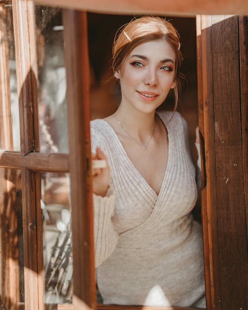 Woman Wearing Gray Top While Standing Near Wooden Window