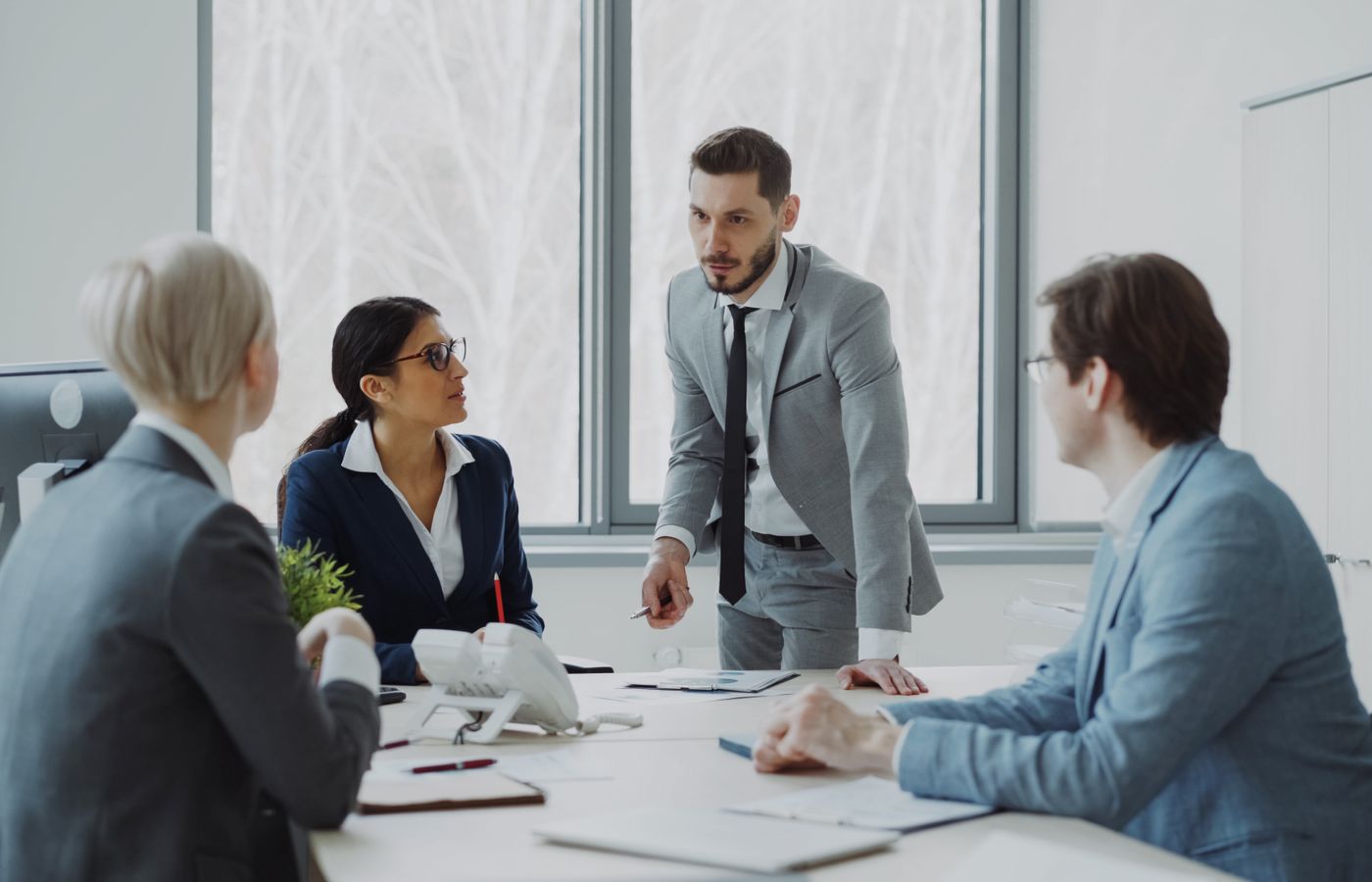 Professionals engaged in a serious business discussion in a bright office environment.
