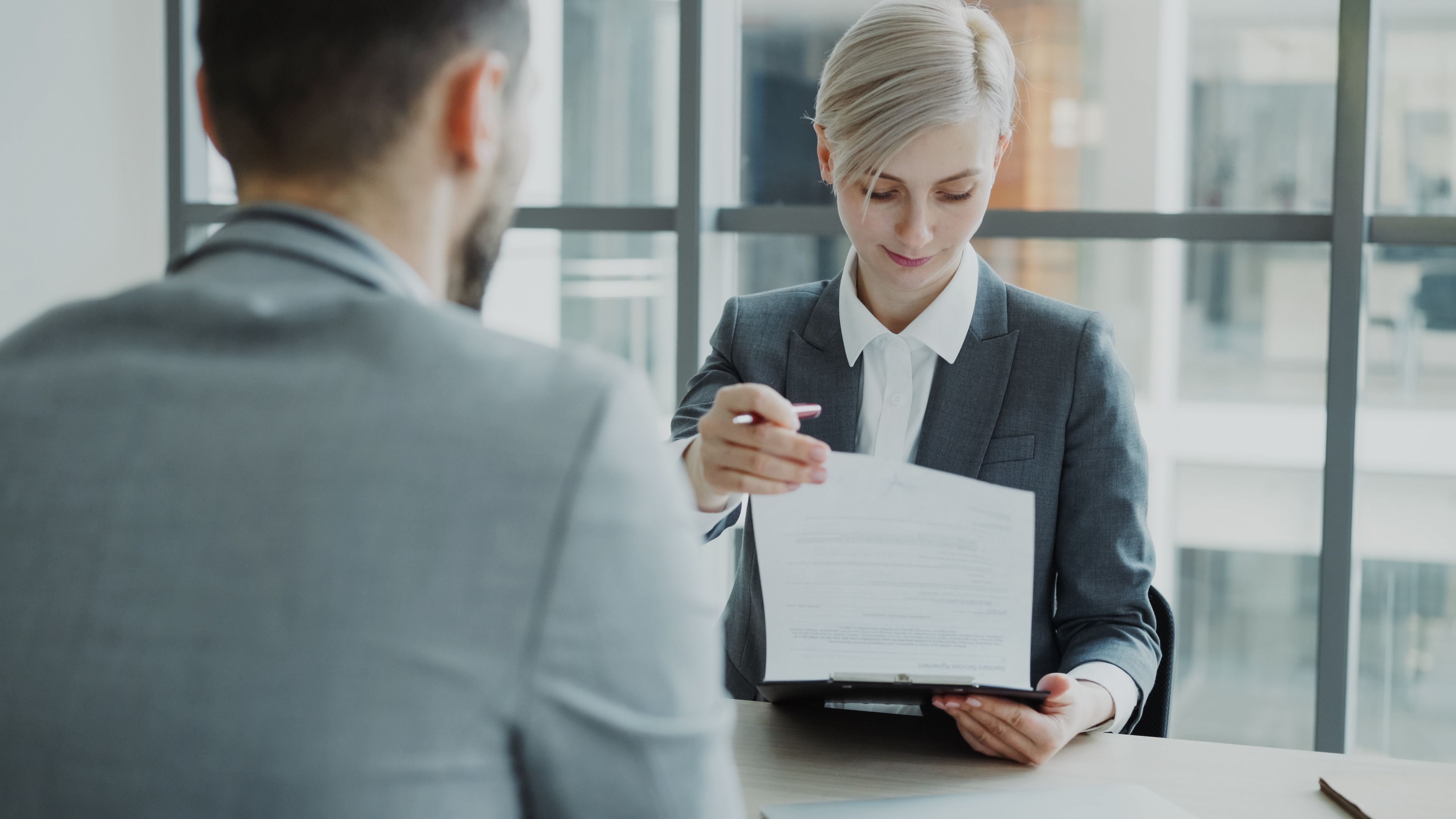 Business professionals reviewing federal contracts in modern office