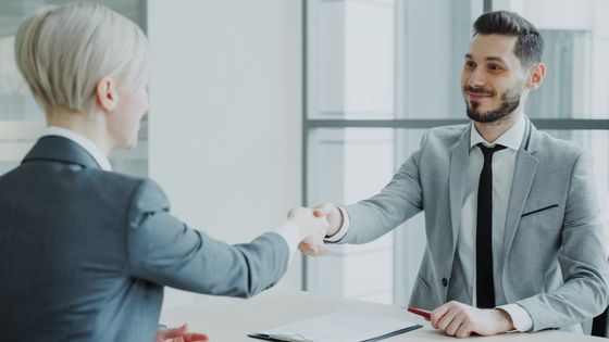 Two professionals shaking hands in a bright office — photo by Vitaly Gariev on Pexels