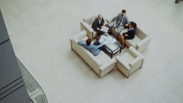 Aerial view of a group business meeting in a modern office setting.