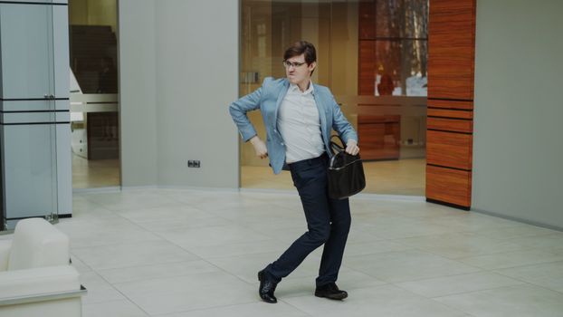 A man in a suit strikes a confident pose in a modern office setting.
