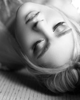 这幅优雅的黑白肖像描绘了一位闭着眼睛的女子，展现了微妙的眼妆