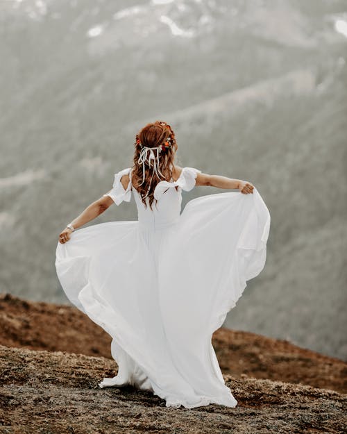 Kahverengi Sahada Duran Beyaz Elbiseli Kadın Arkadan Görünüm Fotoğrafı