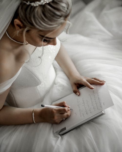 Mulher Em Vestido De Noiva Branco Escrevendo Em Um Livro