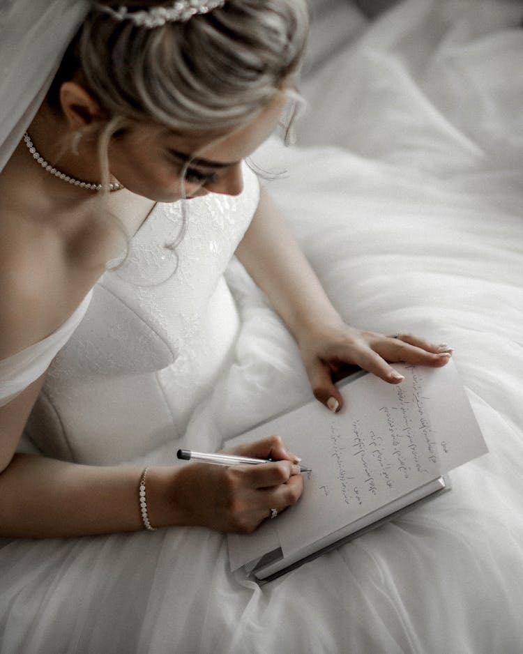 Woman In White Wedding Dress Writing On Book