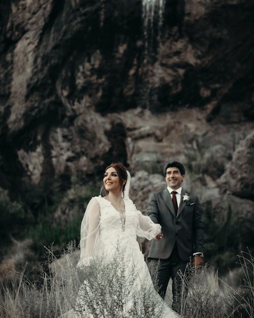 Bride and Groom Standing on Grass Field