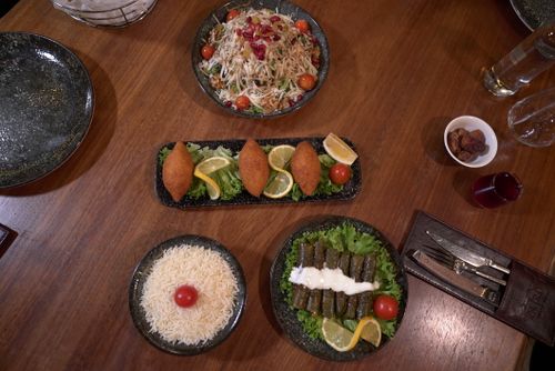 Free A top-down view of a Mediterranean feast with various dishes beautifully arranged on a wooden table. Stock Photo