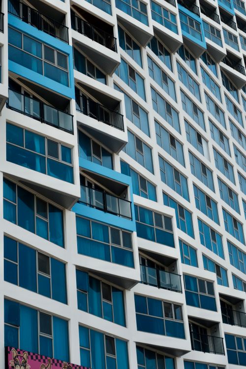 Free Dynamic facade of a modern high-rise building with blue and white geometric patterns. Stock Photo
