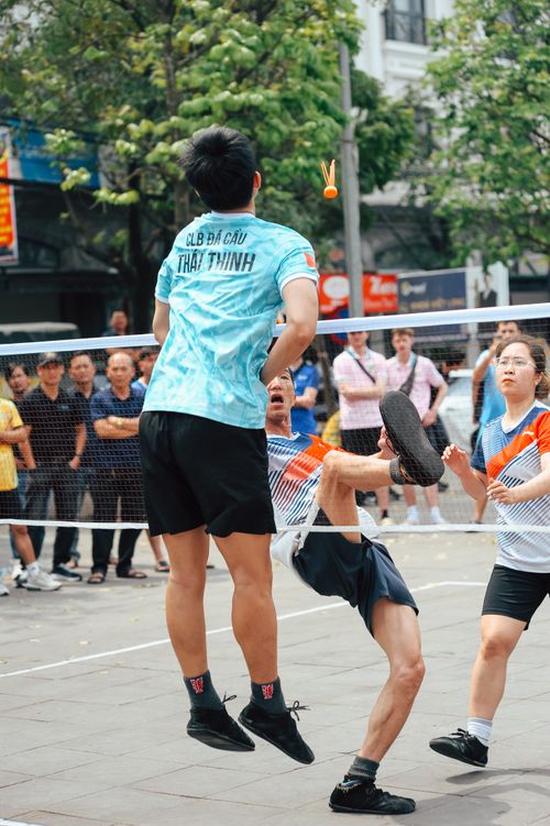 Free Energetic street game of Sepak Takraw with players mid-action and crowd watching. Stock Photo