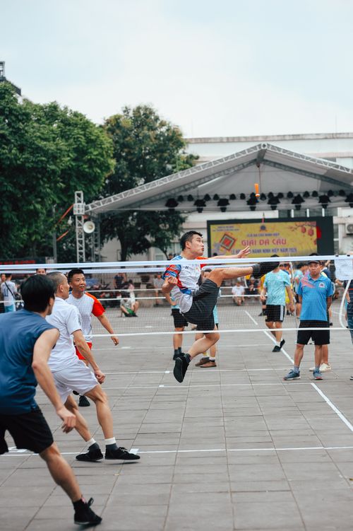 Free A group of men playing Sepak Takraw outdoors in an energetic match. Stock Photo