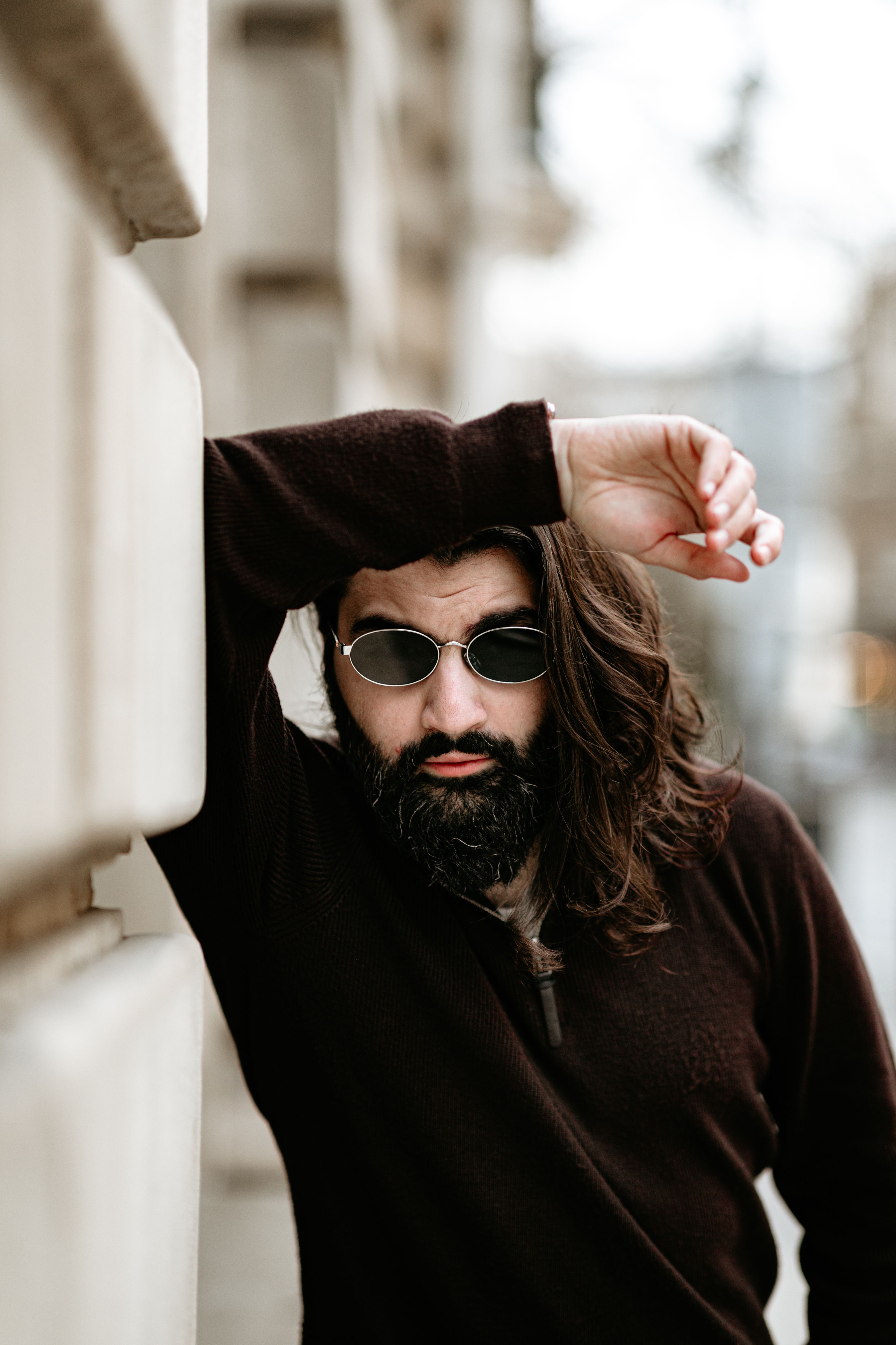 Stylish man with sunglasses leaning against wall · Free Stock Photo