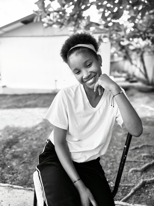 Free A cheerful teenager enjoying a moment outdoors, captured in black and white. Stock Photo