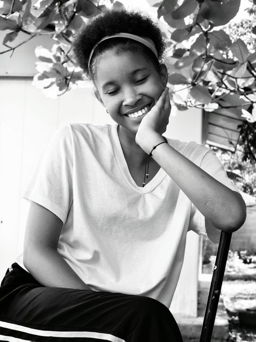 Free Black and white portrait of a young woman smiling outdoors, exuding joy and serenity. Stock Photo