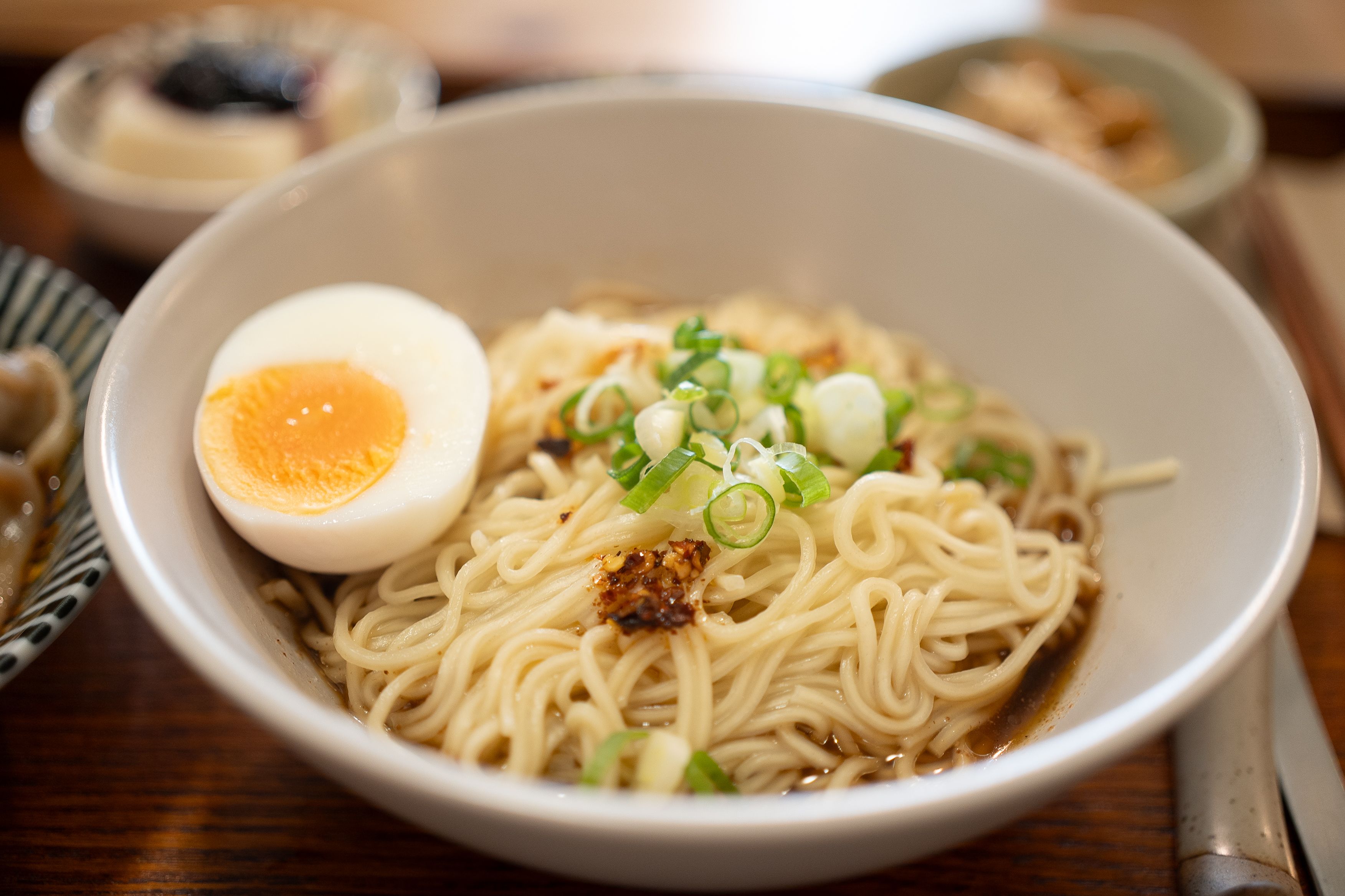 instant ramen bowl with soft-boiled egg, green onions, and chili oil