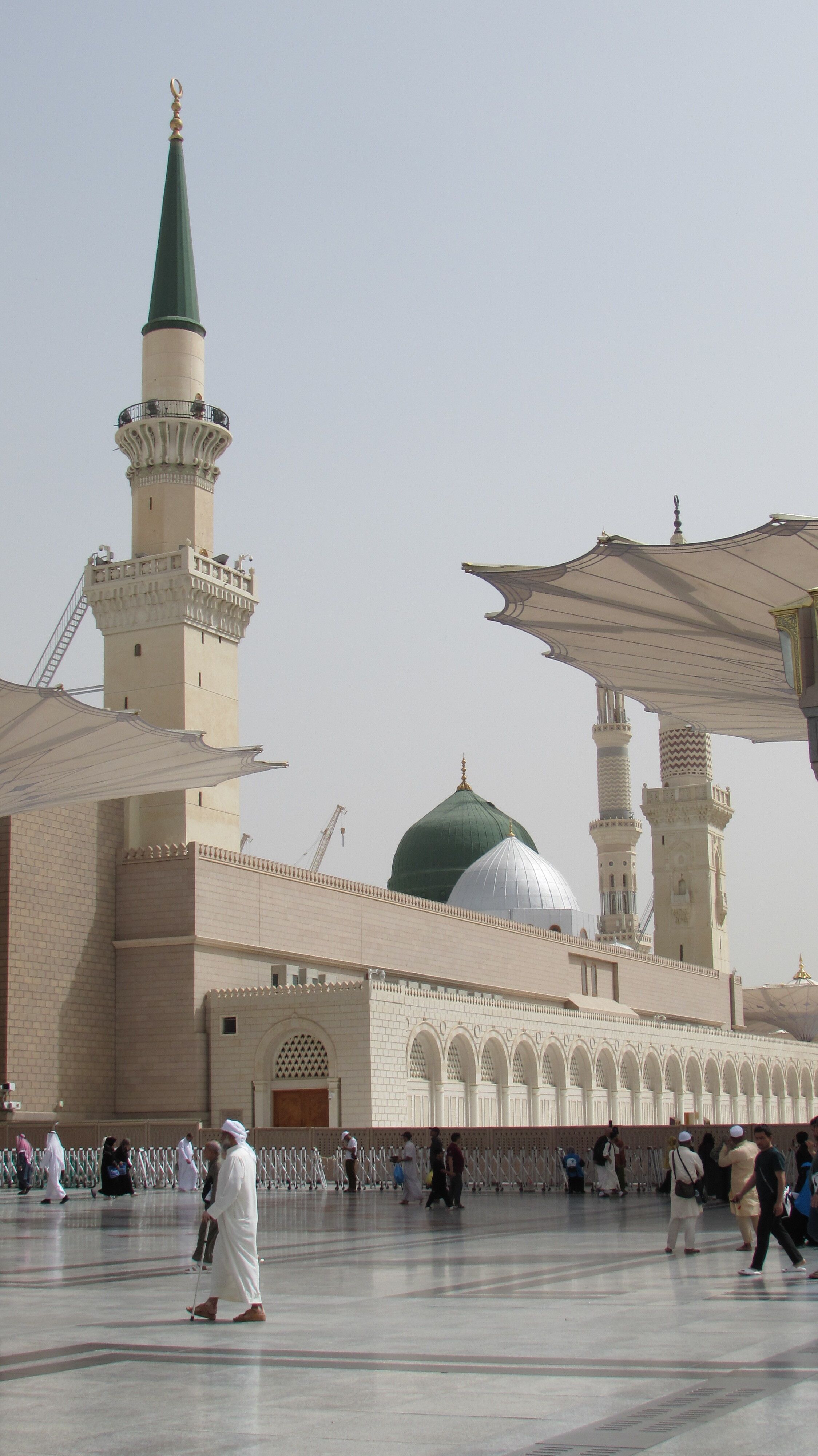 The serene courtyard of the Prophet's Mosque in Madinah, Saudi Arabia, with its iconic green dome.