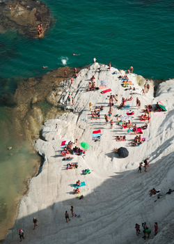 Aerial view of people sunbathing on the white cliffs of Scala dei Turchi in Sicily, Italy.