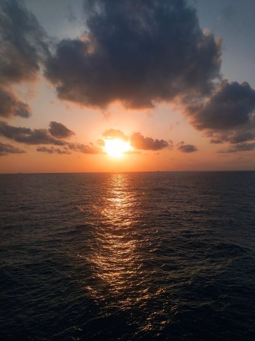 Free Breathtaking sunset over the ocean with vivid clouds and reflection on water. Stock Photo