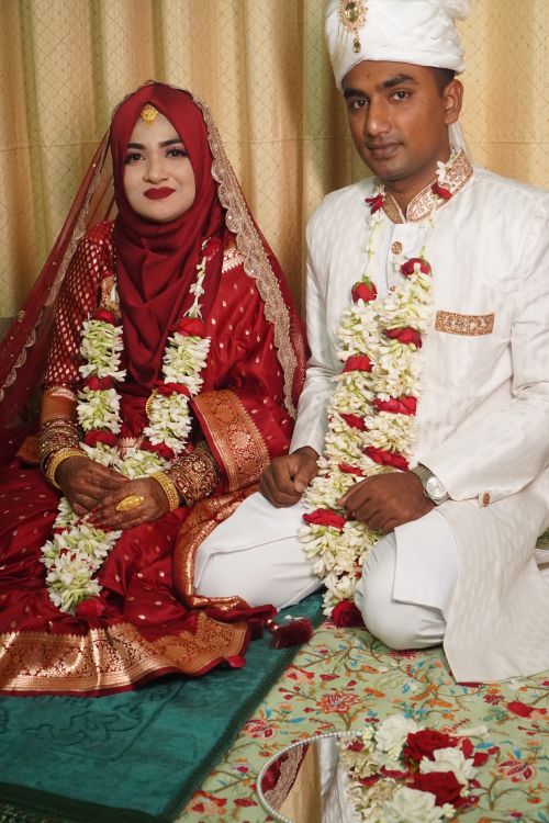 Free A beautifully adorned South Asian couple in traditional wedding attire at their ceremony, showcasing cultural elegance. Stock Photo
