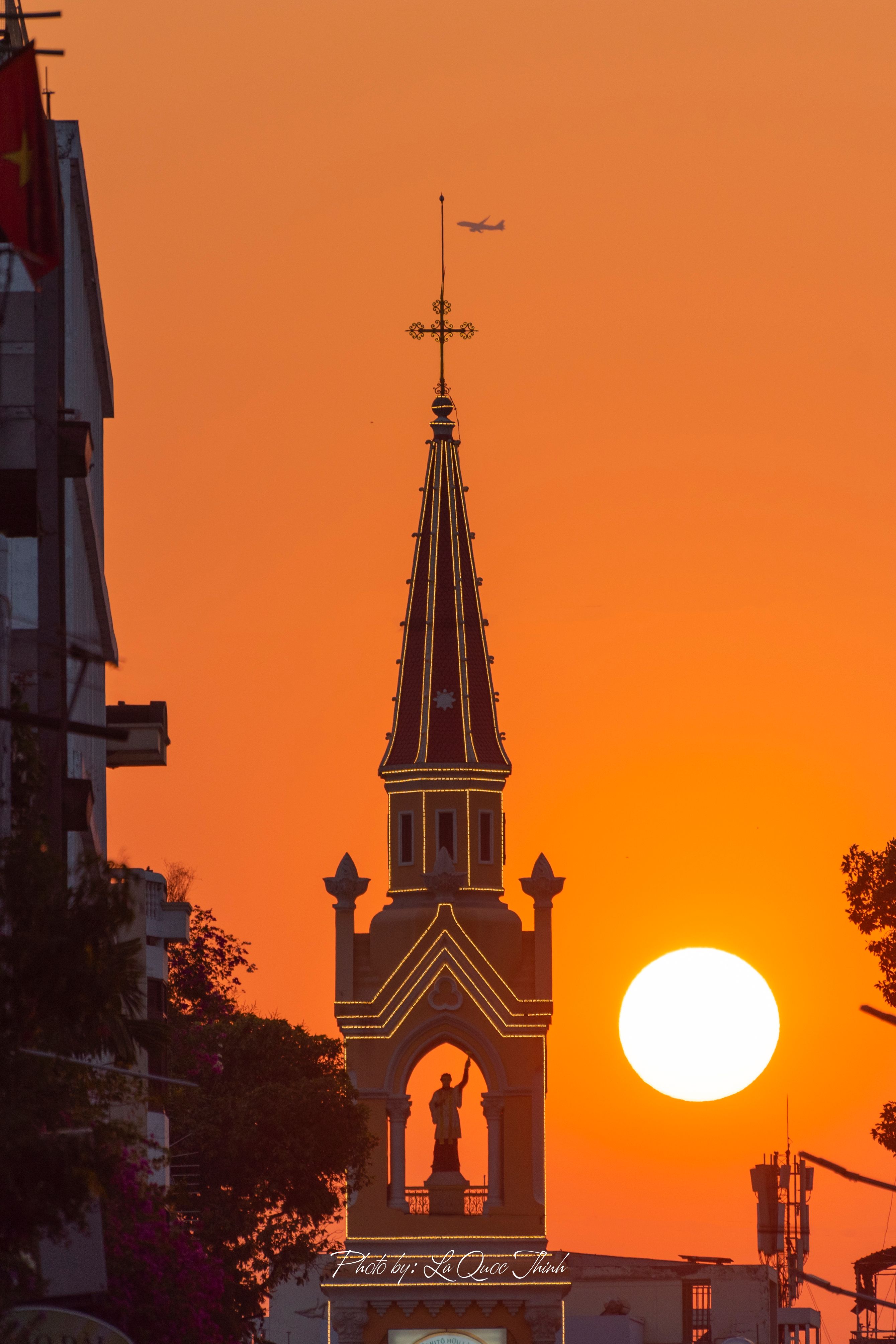 Silhouette of a church against a vivid sunset in Hồ Chí Minh City, Vietnam.