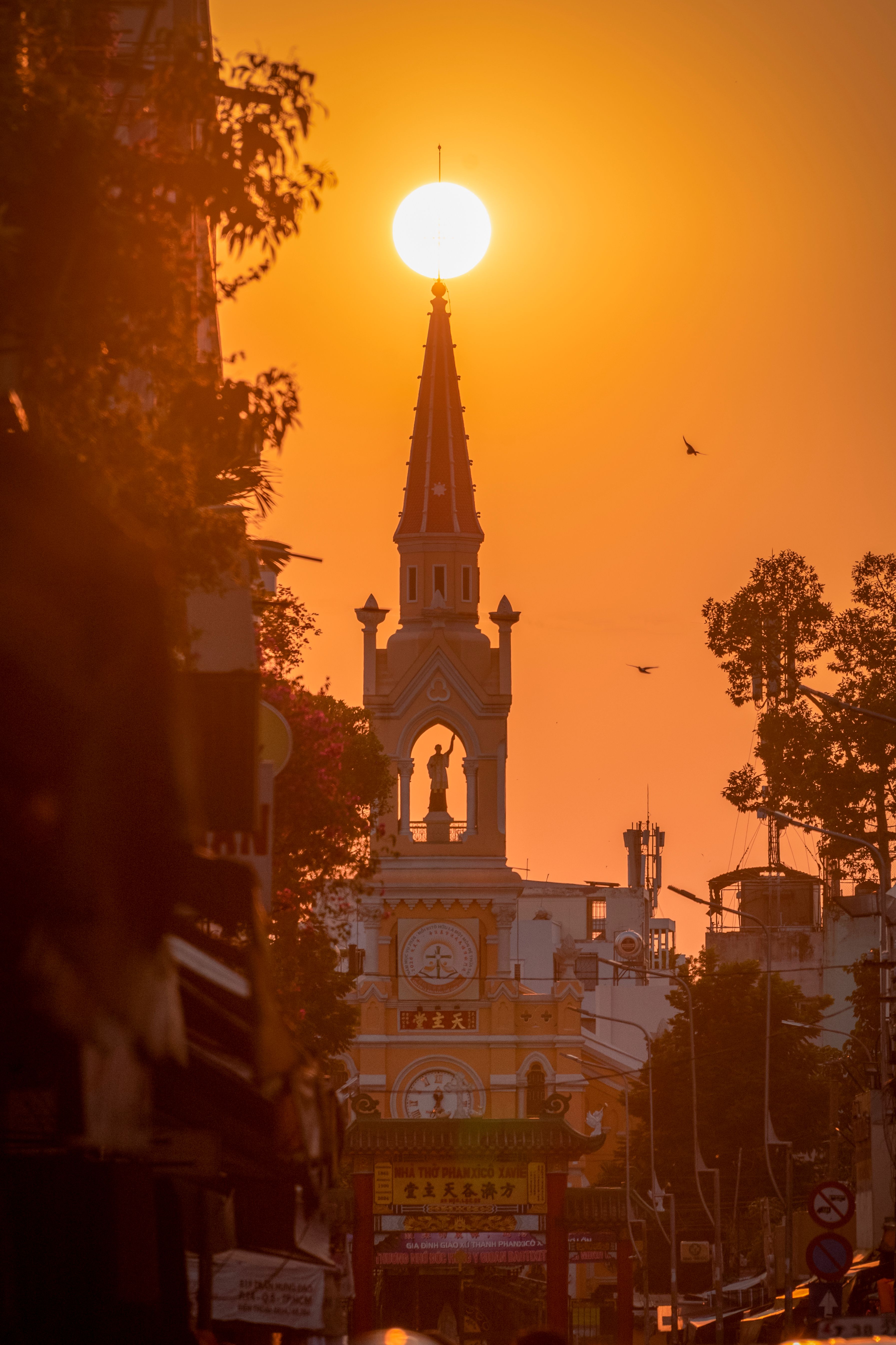 Beautiful sunset over a church in Ho Chi Minh City, capturing its silhouette against a vibrant sky.