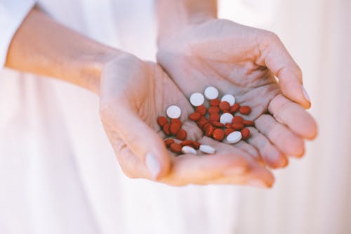 Weiße Und Rote Runde Medikamentenpille Auf Personenhänden