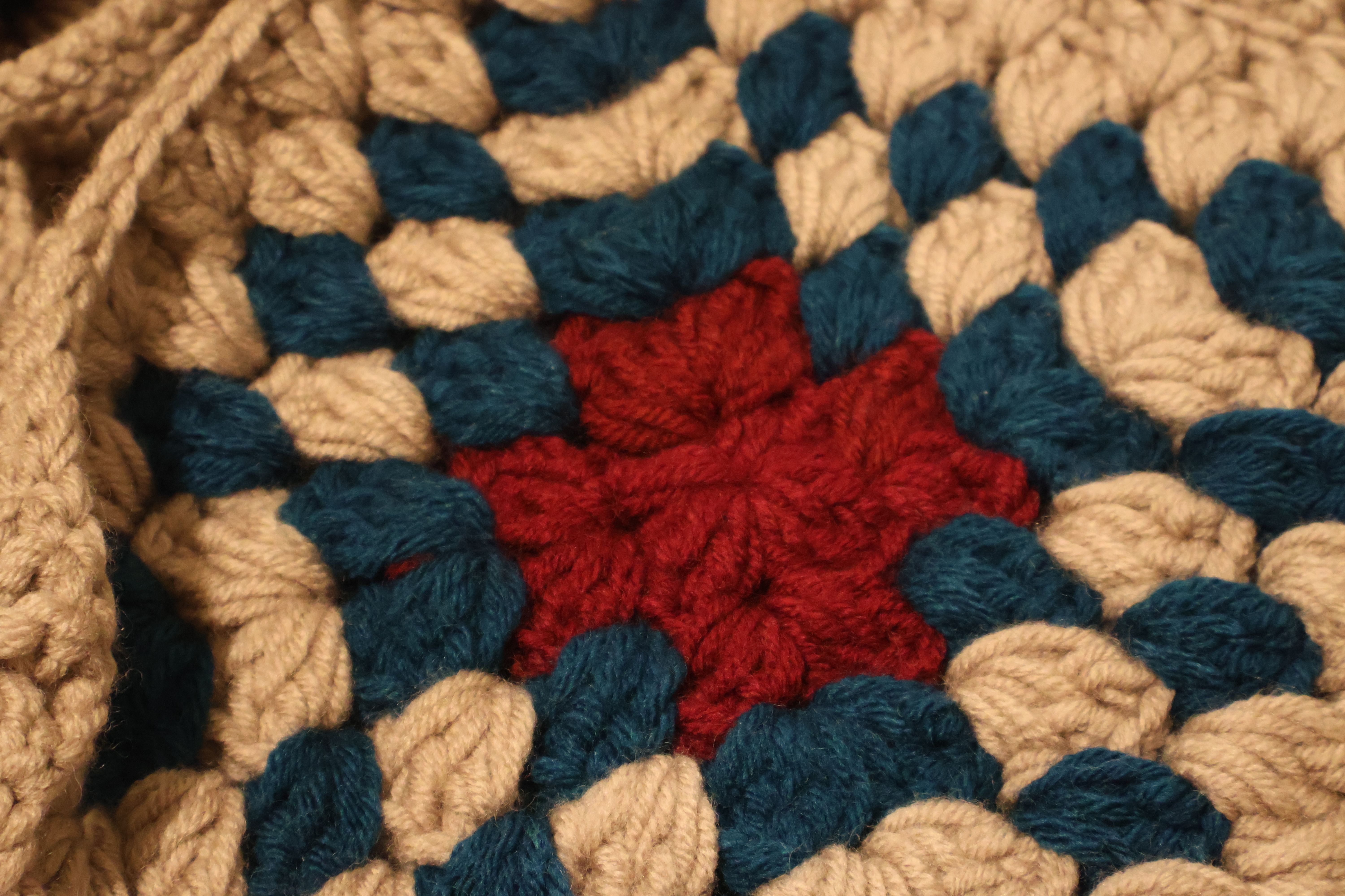 Detailed crochet pattern featuring red, blue, and beige yarn in a geometric design related to how to create unique crochet pa