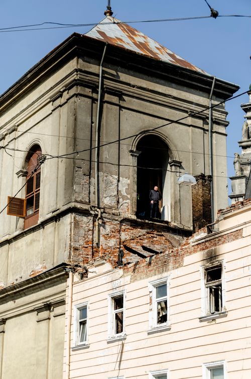 Free A historic building in Lviv, Ukraine, showcases classic architecture with visible renovation work and a person in the window. Stock Photo