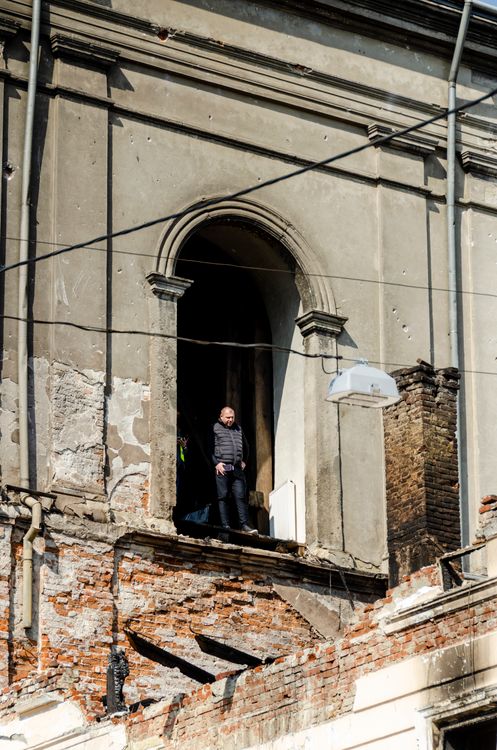 Person Standing on Ruined Lviv Building Facade · Free Stock Photo