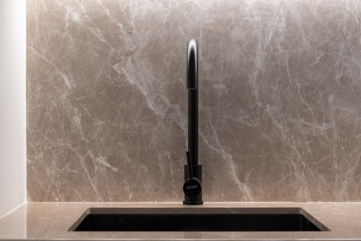 Modern kitchen sink with marble backsplash and sleek black faucet
