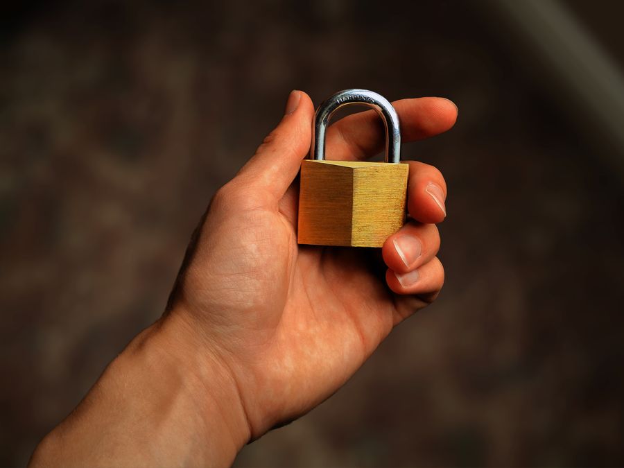 Brass padlock in hand