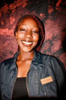 Smiling woman with braided hair against a colorful background
