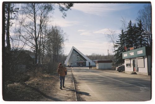 Free A modern triangular building surrounded by trees and rural roads on a clear day. Stock Photo