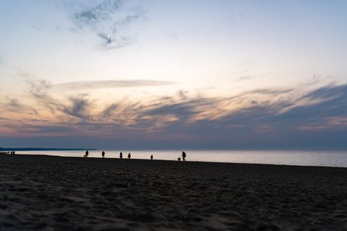 Free Silhouettes of people walking on Kołobrzeg beach during a stunning sunset. Stock Photo